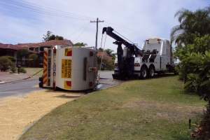 tow truck with a crane recovering a rolled truck