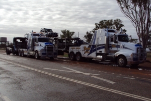 two tow trucks towing heavy loads
