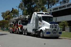 tow truck transporting a broken down fire truck