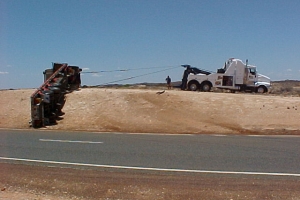 tow truck recovering a rolled tuck