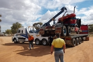freightliner Coronado loading truck onto flat top tow truck